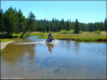 Honda CRF Motorcycle crossing the water at Lower Blue Lake Trail