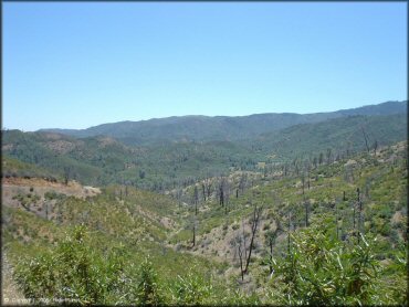 A scenic view of hills, trees and hills.