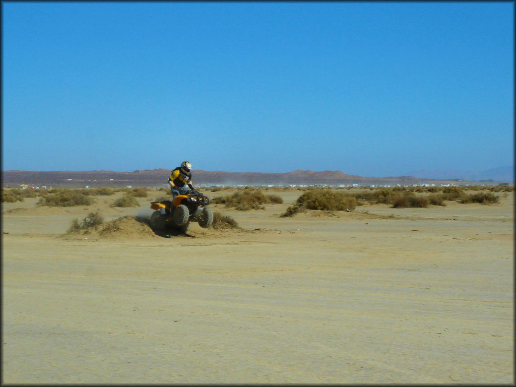 Man on Honda 250 ATV catching a little air.